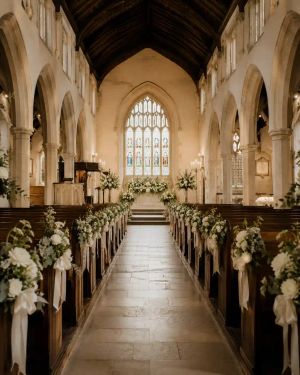 An empty church aisle softly lit, ready for a wedding ceremony.