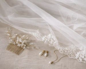 A bridal veil laid out beside a hair comb and simple jewellery.